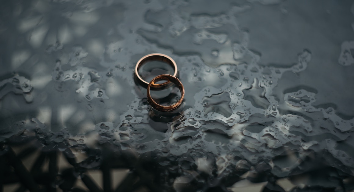 two wedding rings lying in a puddle of water